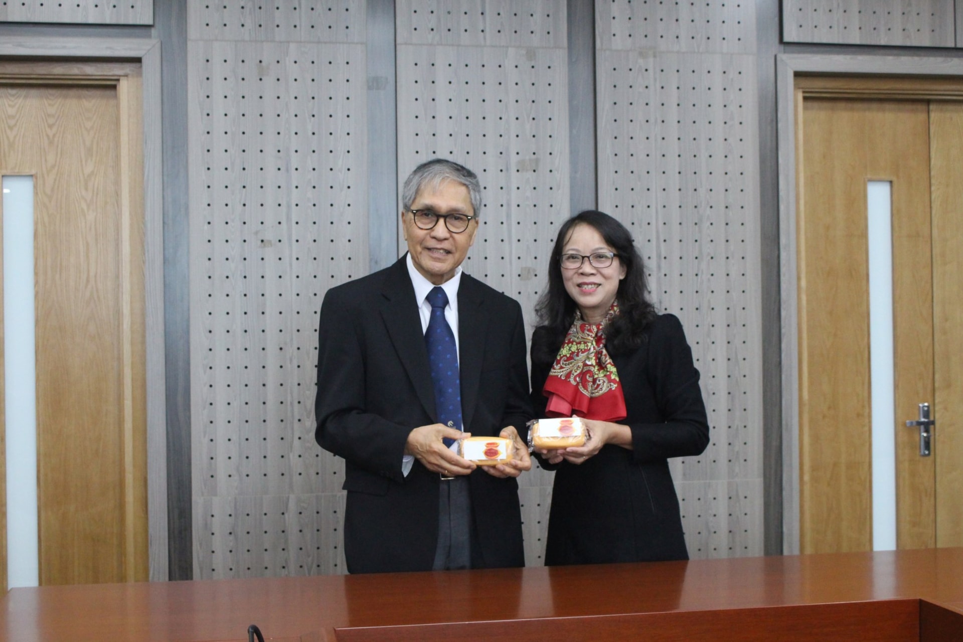 PGS. Nguyễn Minh, đại diện Trường Đại học Newcastle tặng sản phẩm được làm từ gấc  cho Thứ trưởng, Phó Chủ nhiệm Hoàng Thị Hạnh.