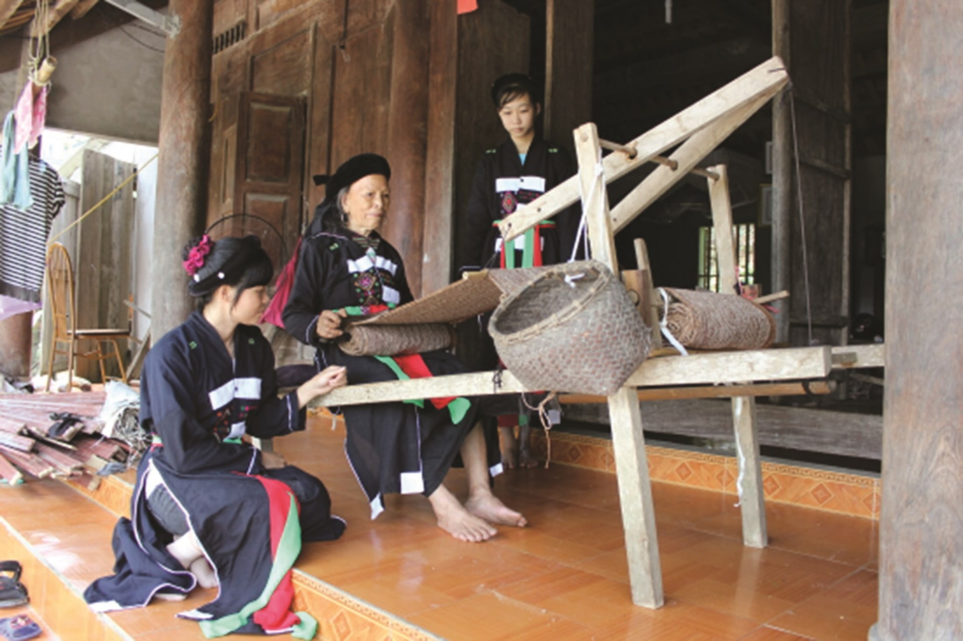 Nghệ nhân Trạc Thị Ngọn (ngồi giữa) hướng dẫn các hội viên cách  dệt thổ cẩm