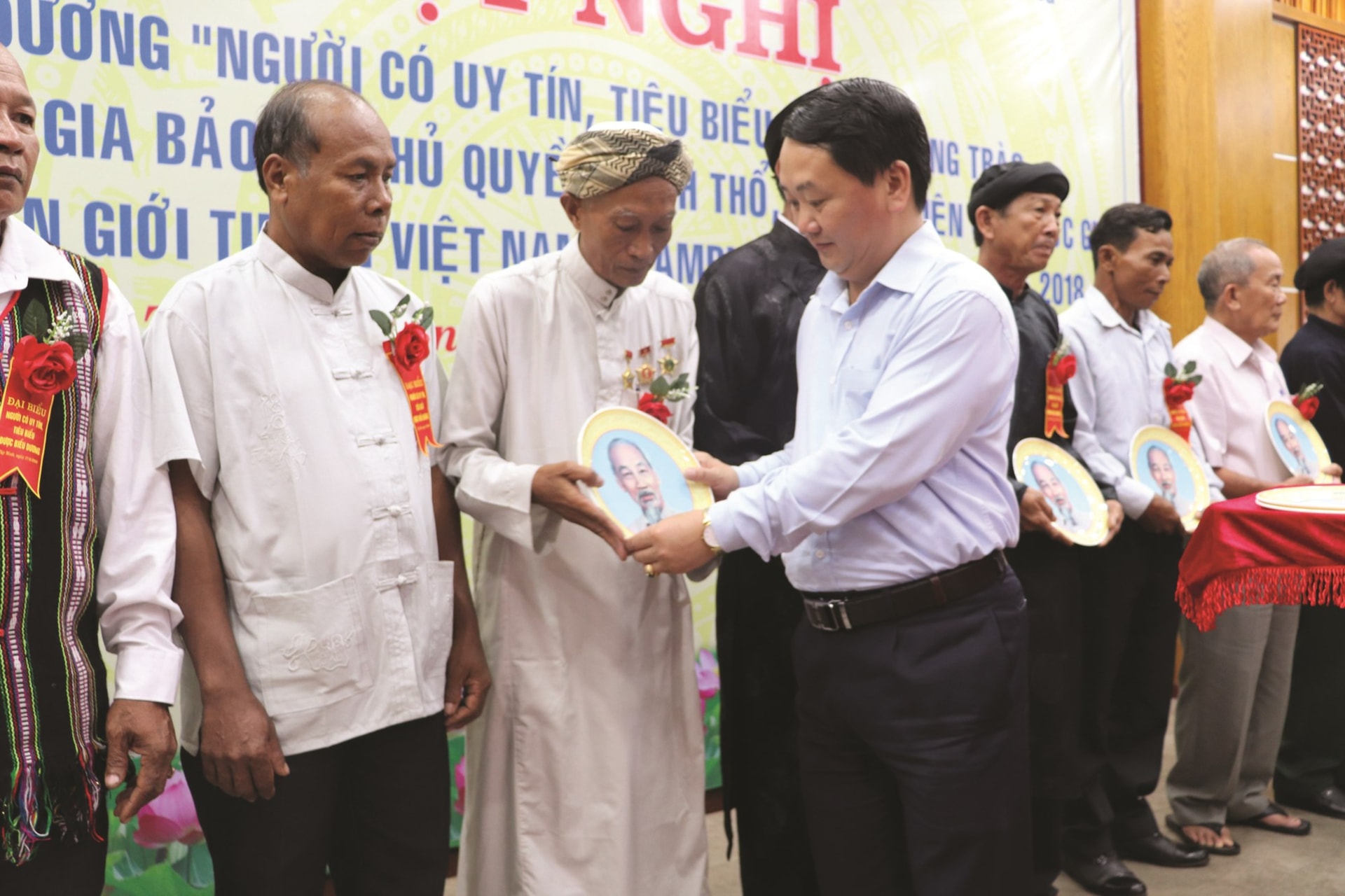 Ông Hầu A Lềnh, Phó Chủ tịch, Tổng Thư  ký Ủy ban Trung ương MTTQ Việt Nam trao quà cho Giáo Cả A Ly tại Hội nghị Tuyên dương “Người có uy tín tiêu biểu trong phong trào Toàn dân tham gia bảo vệ chủ quyền lãnh thổ, an ninh biên giới quốc gia” giai đoạn 2009 - 2018