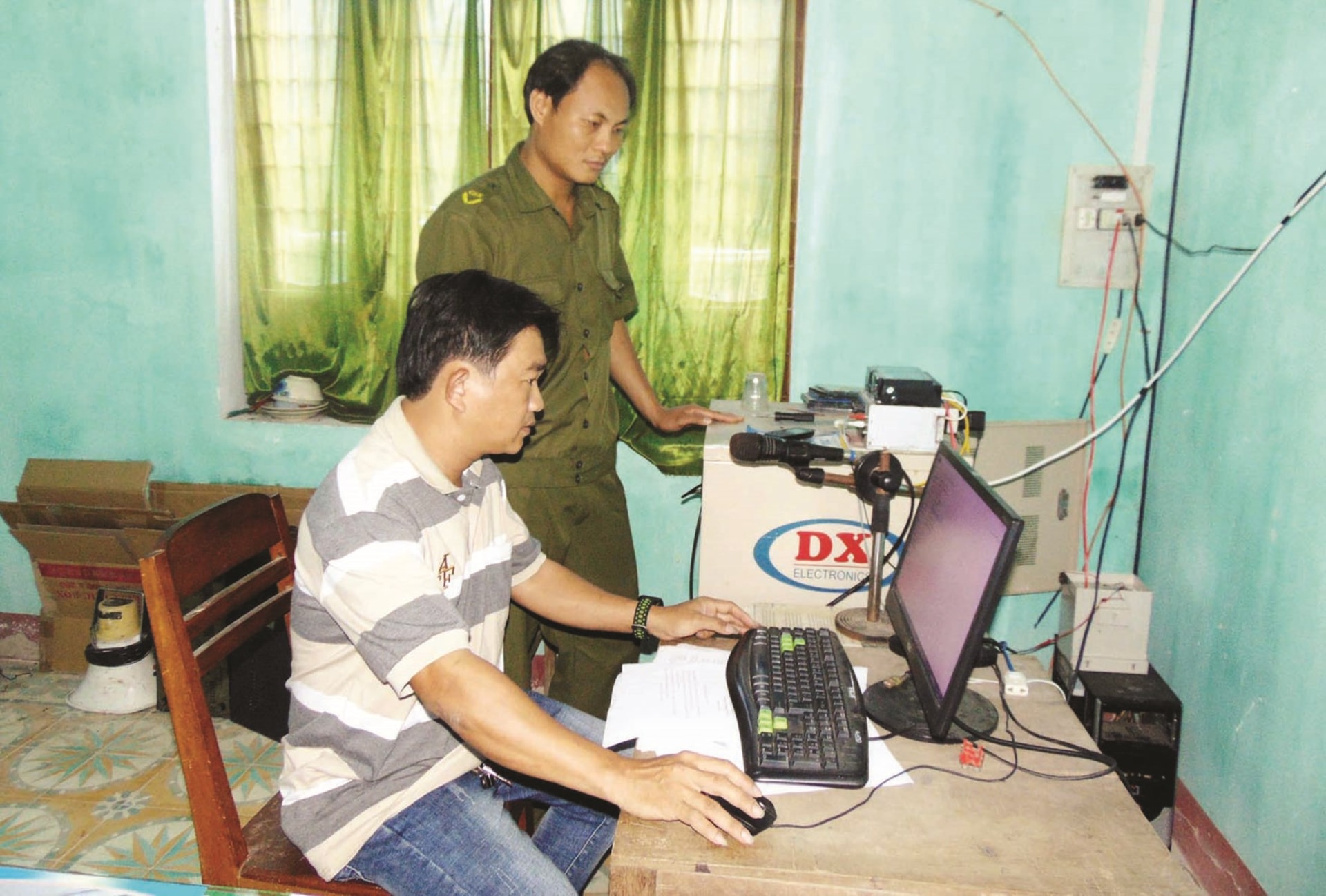 Công an xã Bình Đào và cán bộ Đài truyền thanh kiểm tra trung tâm điều khiển hệ thống loa phát thanh.