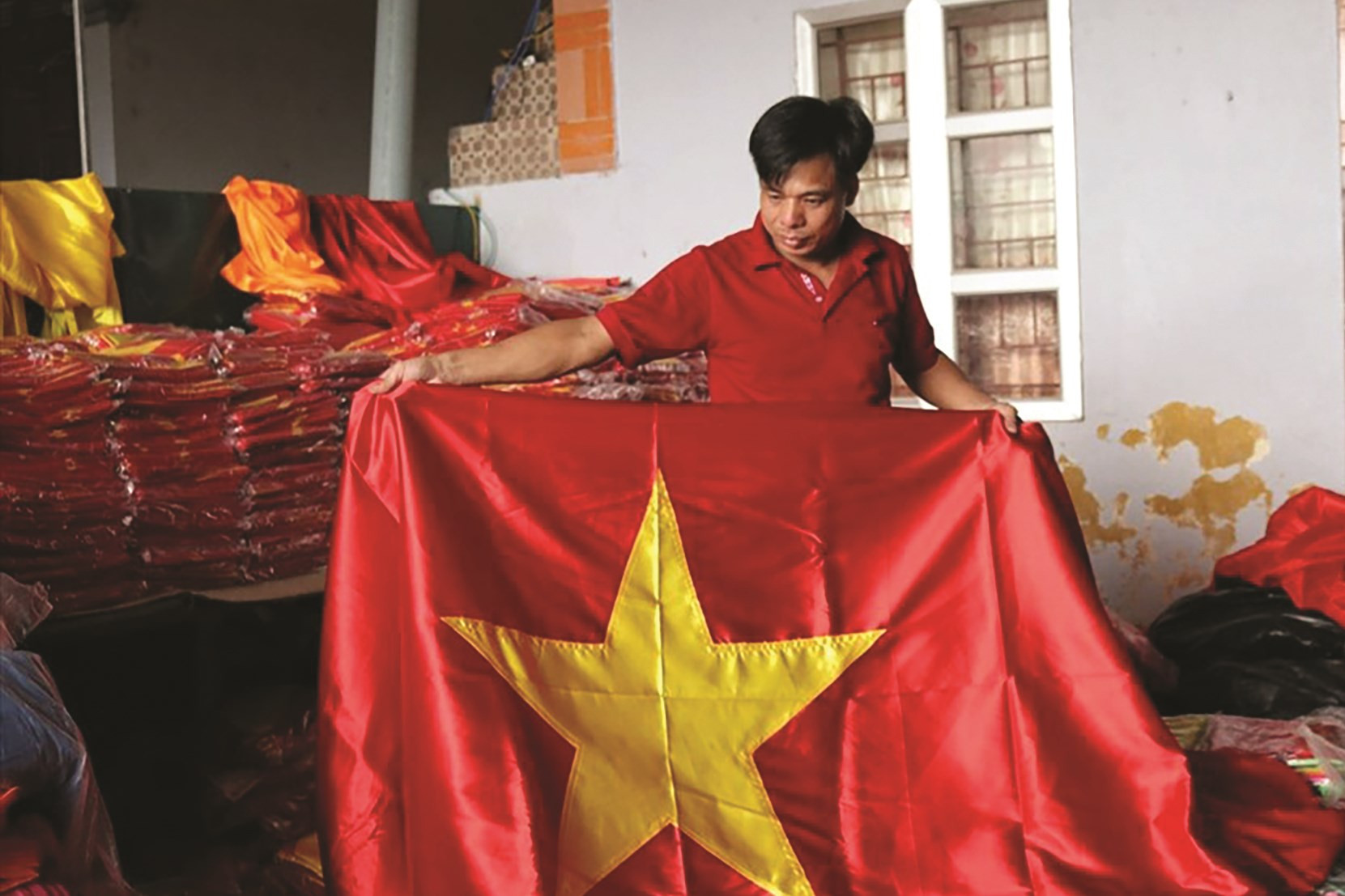 Anh Nguyễn Văn Phục (làng Từ Vân) kiểm tra lá cờ Tổ quốc sau khi vừa hoàn thiện sản phẩm
