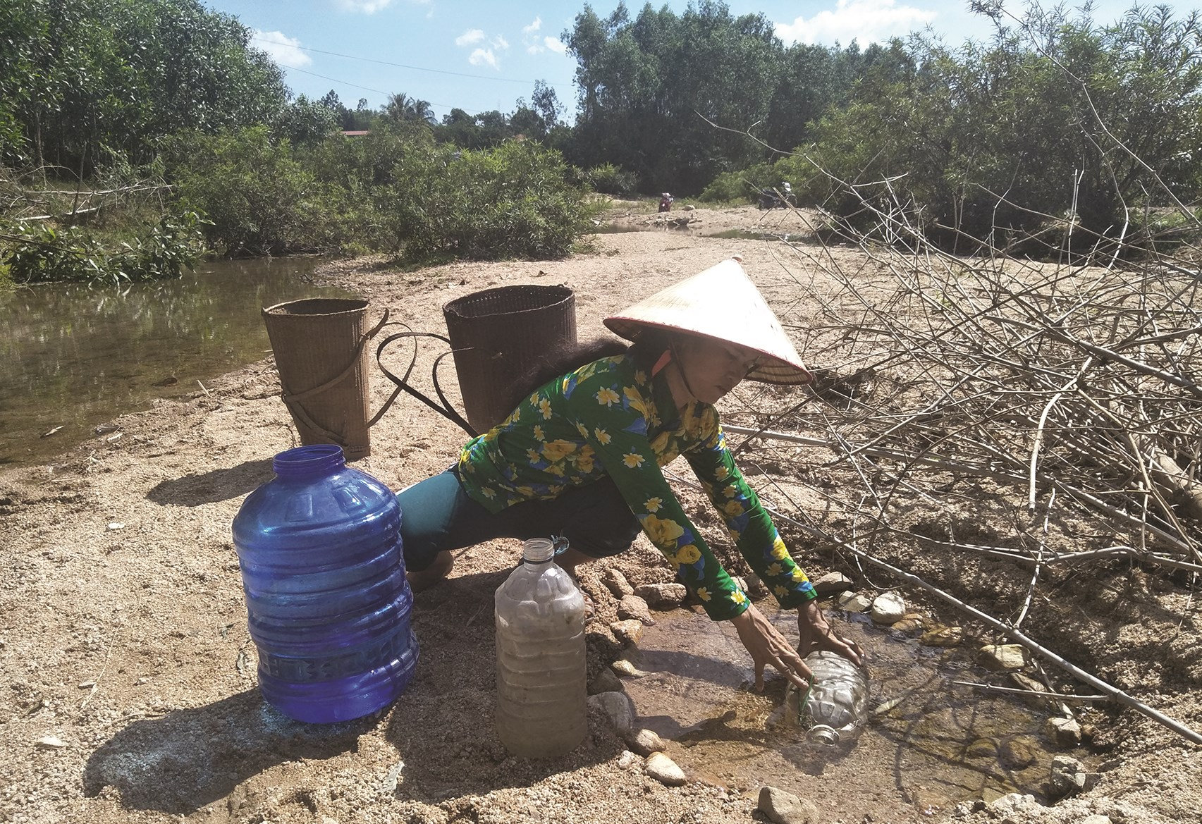 Người dân Vân Canh thiếu nước sinh hoạt phải ra suối múc từng can nước về dùng 