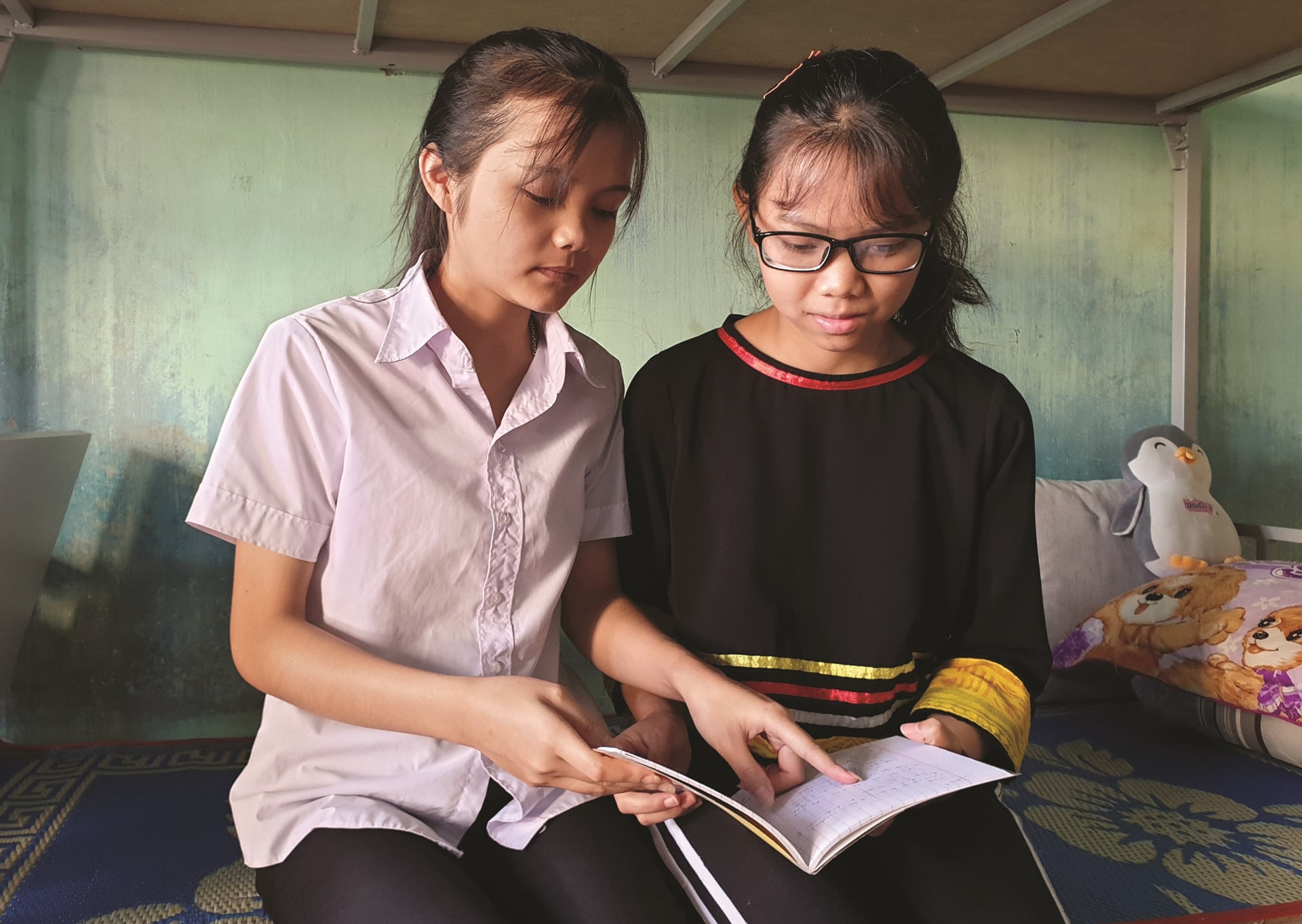 Ngoài giờ học trên lớp, Rơ Châm Ling (bên phải)  cũng tranh thủ giúp đỡ bạn bè học tập