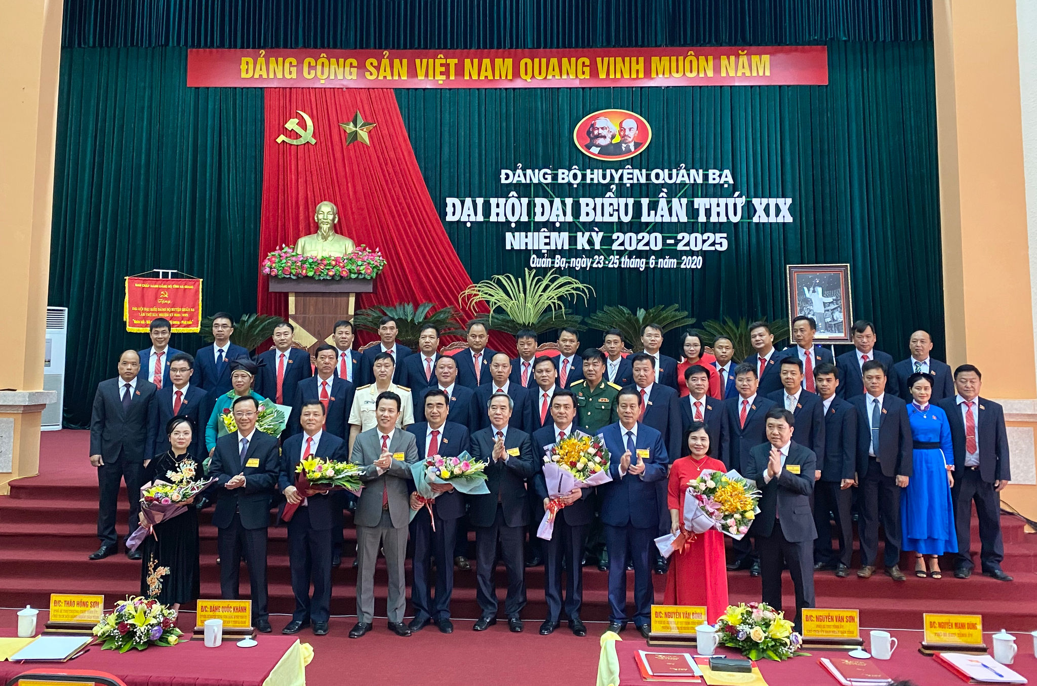 Đồng chí Nguyễn Văn Bình, Trưởng ban Kinh tế Trung ương; đồng chí Đặng Quốc Khánh, Bí thư Tỉnh ủy Hà Giang tặng hoa chúc mừng Ban Chấp hành Đảng bộ huyện Quản Bạ khóa XIX, nhiệm kỳ 2020 – 2025.