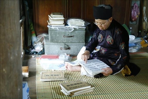 Ông Thanh đam mê, gắn bó với những tư liệu cổ của người Dao. Ảnh: Nam Sương - TTXVN