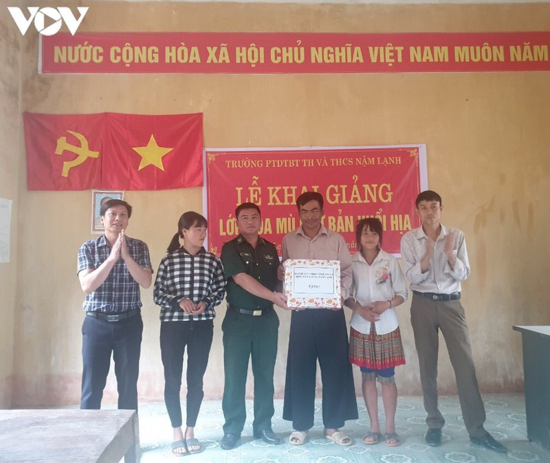 Tặng quà cho bản và phát sách vở cho các học viên tại Lễ Khai giảng Lớp xóa mù chữ ở bản đồng bào Mông Huổi Hịa, xã Nậm Lạnh, Sốp Cộp.