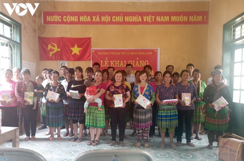 Tặng quà cho bản và phát sách vở cho các học viên tại Lễ Khai giảng Lớp xóa mù chữ ở bản đồng bào Mông Huổi Hịa, xã Nậm Lạnh, Sốp Cộp.