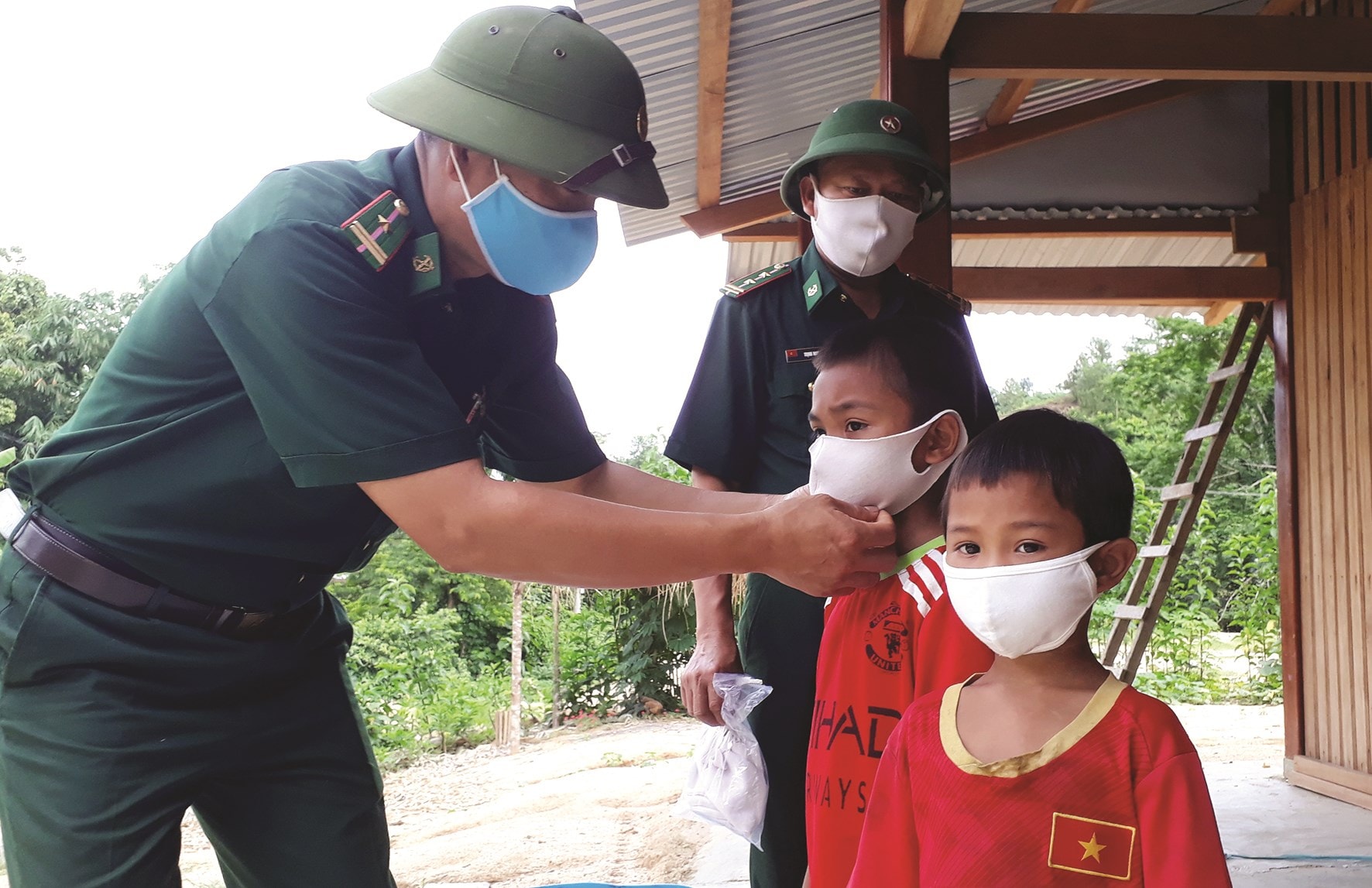 Các chiến sĩ ĐBP Đắc Pring hướng dẫn trẻ em biên giới đeo khẩu trang đúng cách nhằm phòng dịch Covid-19
