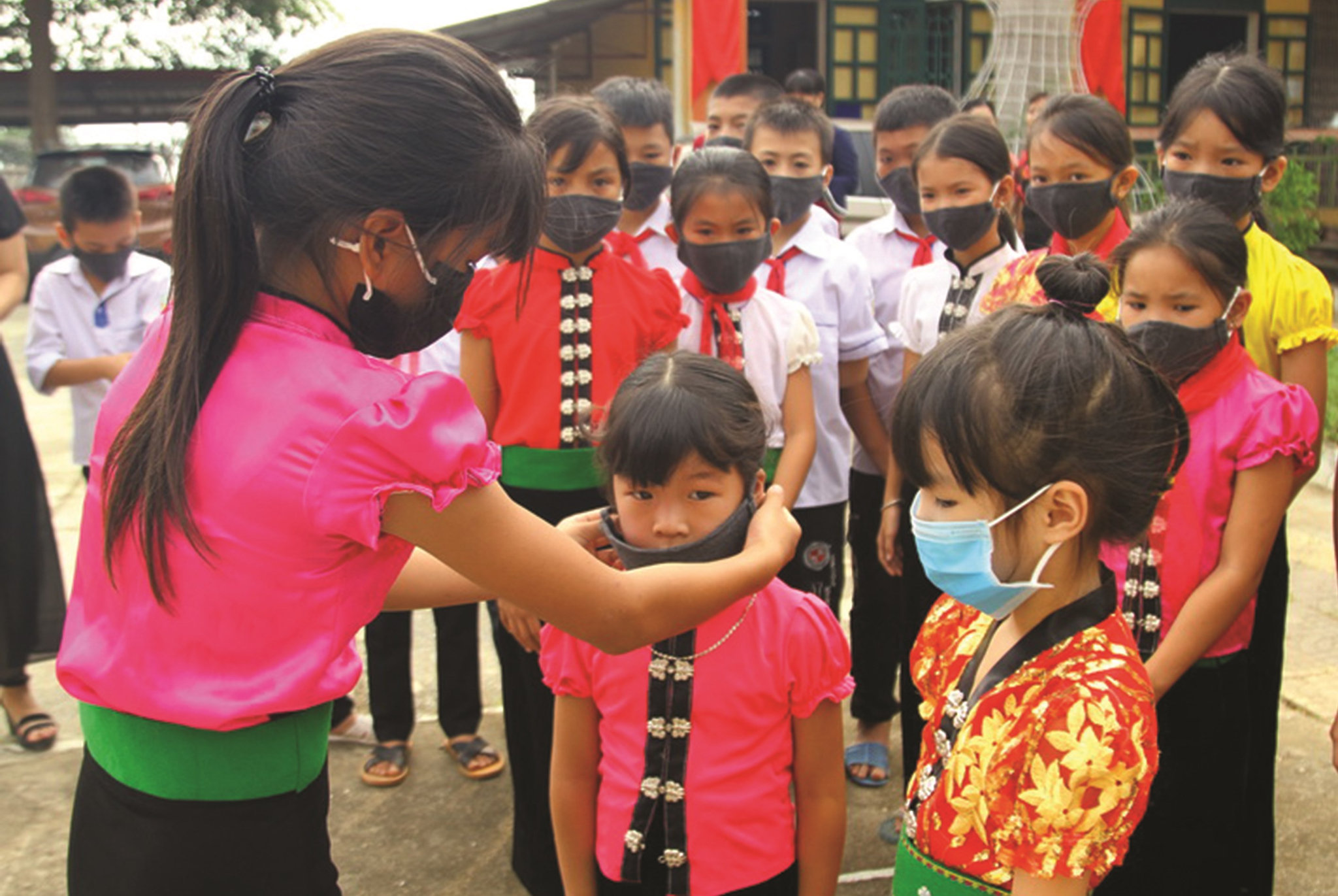 Các em học sinhTrường Tiểu học Phúc Sơn,thị xã Nghĩa Lộ, Yên Bái, được các chị lớp lớn hướng dẫn đeo khẩu trang phòng dịch trong ngày tựu trường. Ảnh: Việt Hà