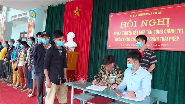 Nhiều cá nhân và gia đình ở xã Xín Cái ký cam kết không vi phạm pháp luật về xuất, nhập cảnh. Ảnh: Nguyễn Chiến - TTXVN