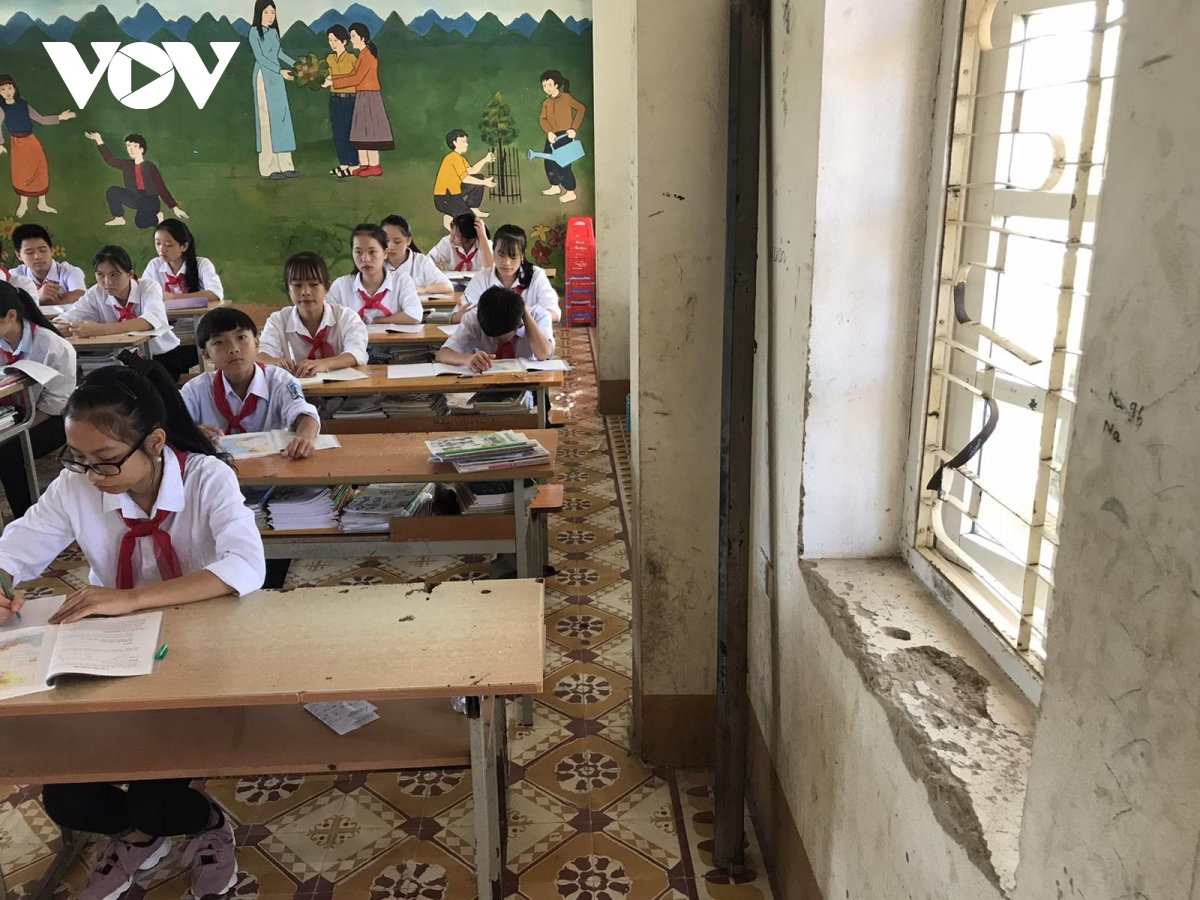 Máy chiếu đã hỏng từ lâu được dựng vào 1 góc tường đã bong tróc.