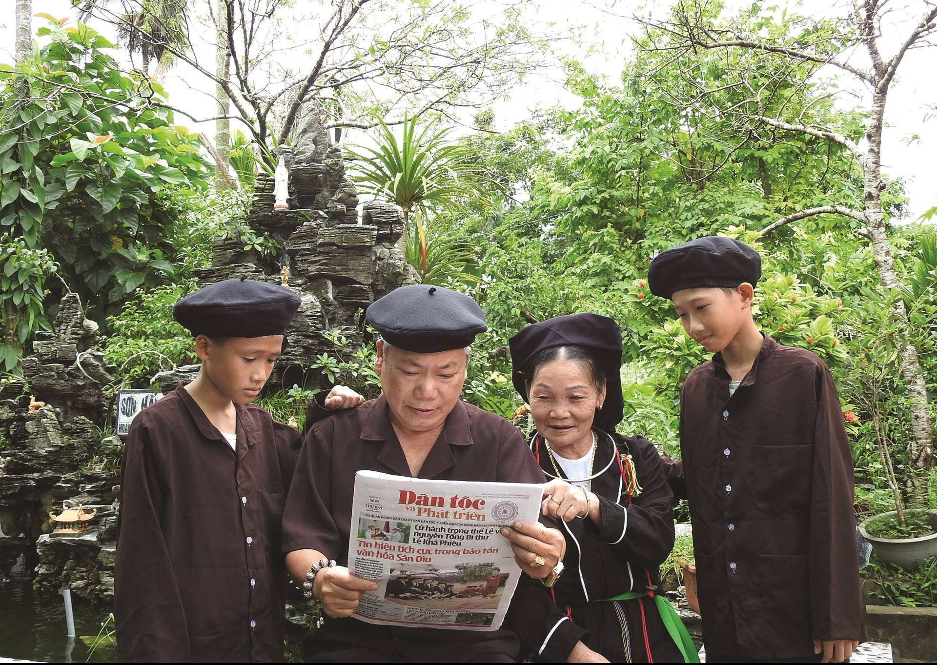 Ông Lục Văn Bảy chia sẻ thông tin trên Báo Dân tộc và Phát triển với các thành viên trong gia đình