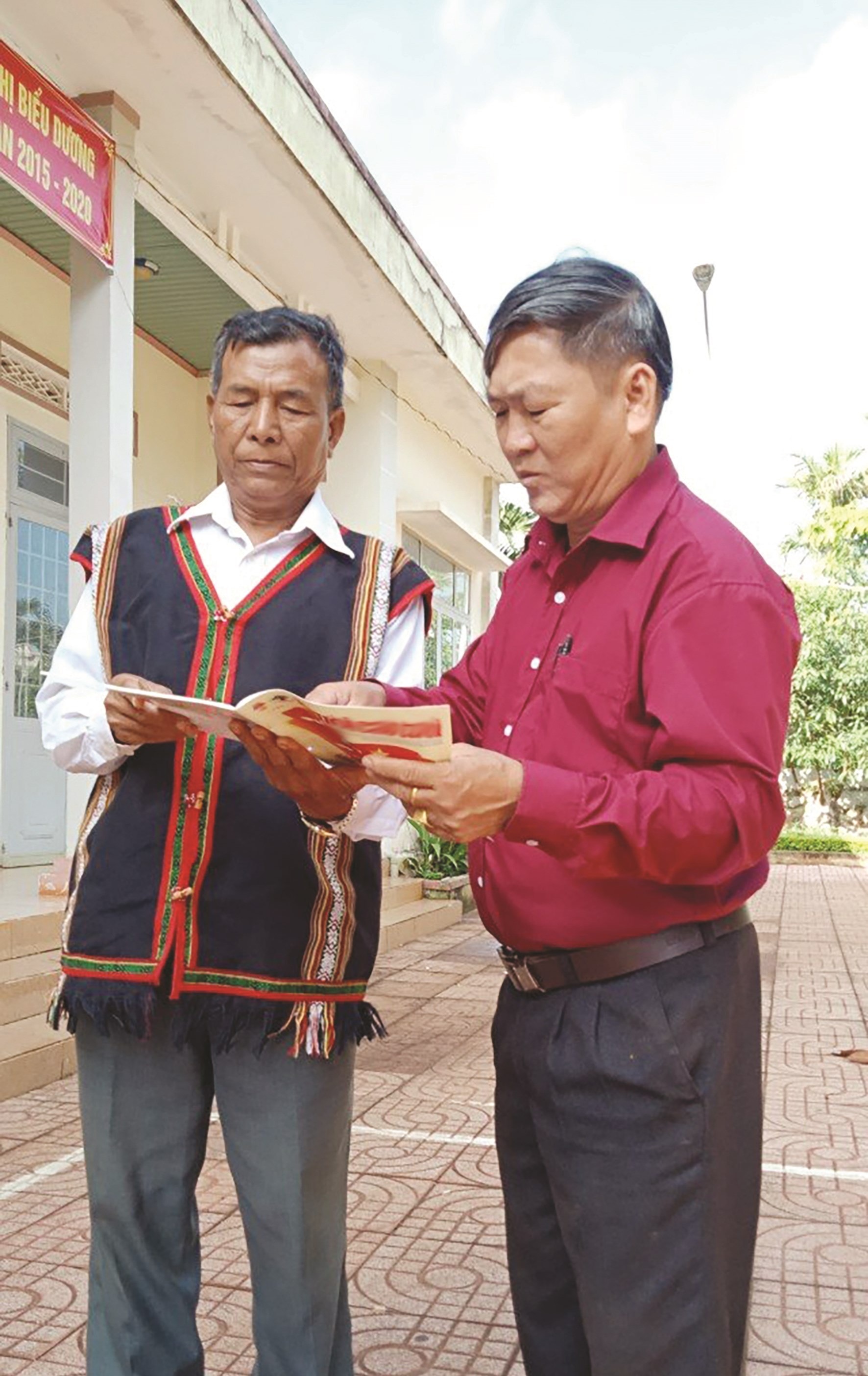 Già làng Y Đá (bên trái) chia sẻ kinh nghiệm vận động quần chúng