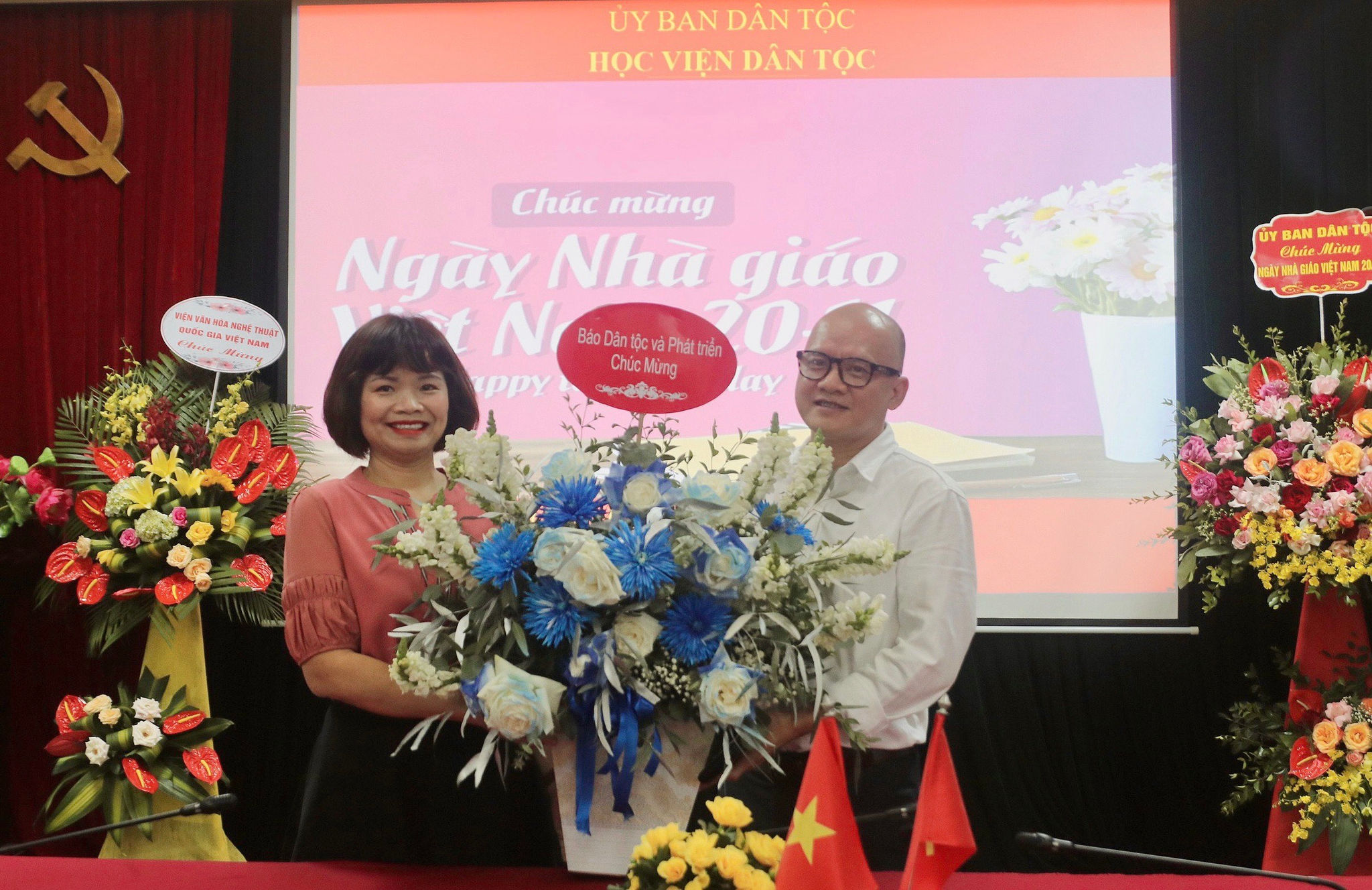 Phó Tổng Biên tập Báo Dân tộc và Phát triển Bùi Thị Hạ tặng hoa chúc mừng Học viện Dân tộc