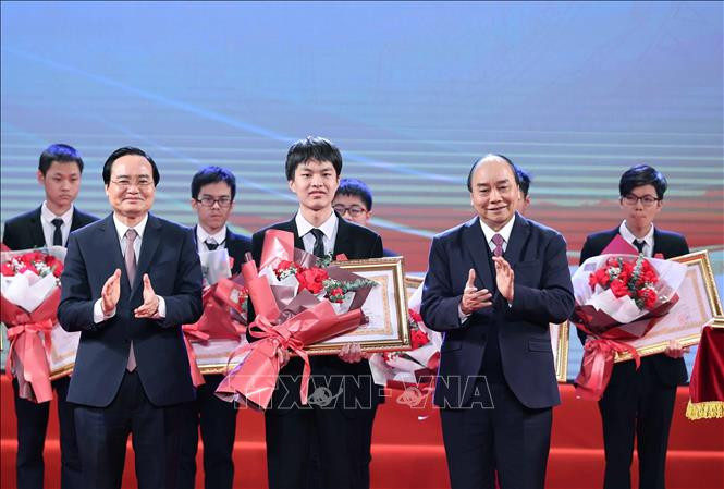 Thủ tướng Nguyễn Xuân Phúc, Chủ tịch Hội đồng Thi đua - Khen thưởng Trung ương trao tặng Huân chương lao động hạng Ba cho em Lê Quang Huy, học sinh lớp 11, trường THPT chuyên Khoa học Tự nhiên, trường Đại học Tự nhiên, Đại học Quốc gia Hà Nội, đã đoạt Huy chương Vàng Olympic Sinh học Quốc tế năm 2020. Ảnh: Thống Nhất/TTXVN