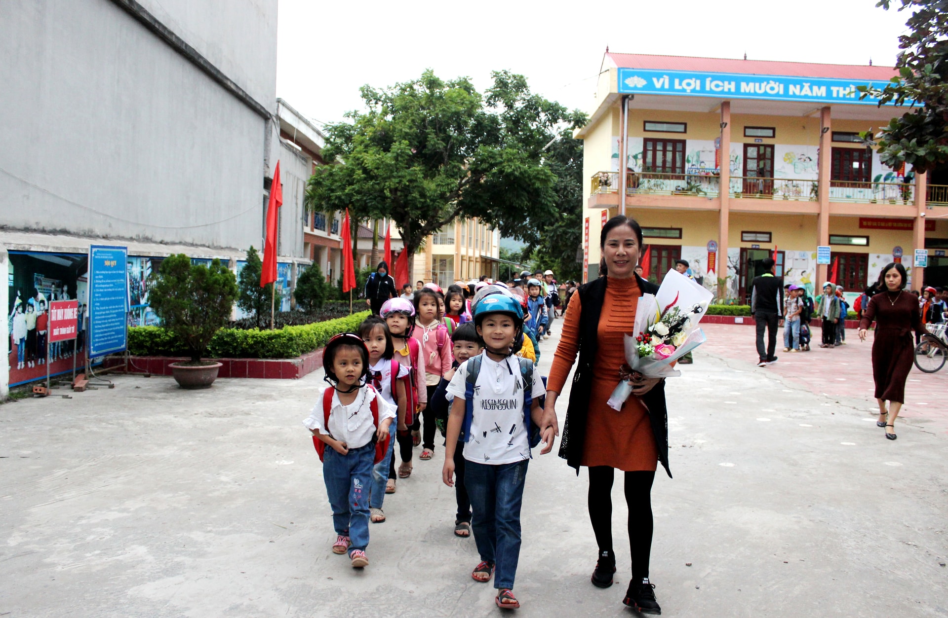 Cô giáo chủ nhiệm đưa học sinh xếp hàng ra khỏi cổng trường