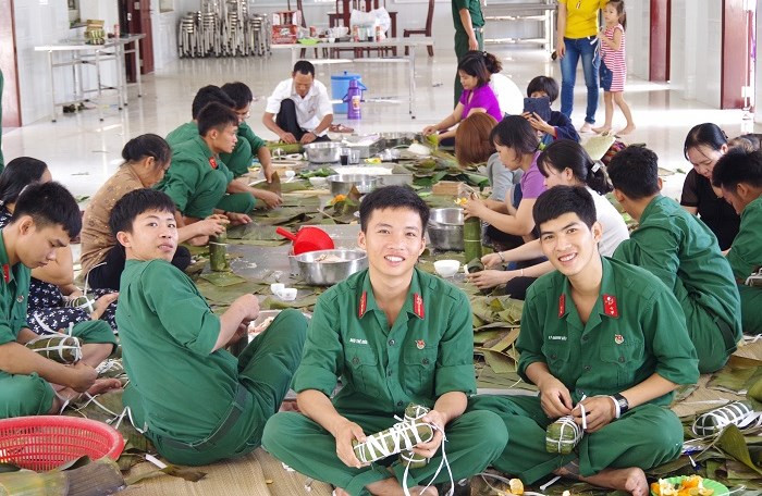 Cán bộ, chiến sĩ quây quần gói bánh chưng, bánh tét cùng với quần chúng Nhân dân tại khu vực đóng quân.