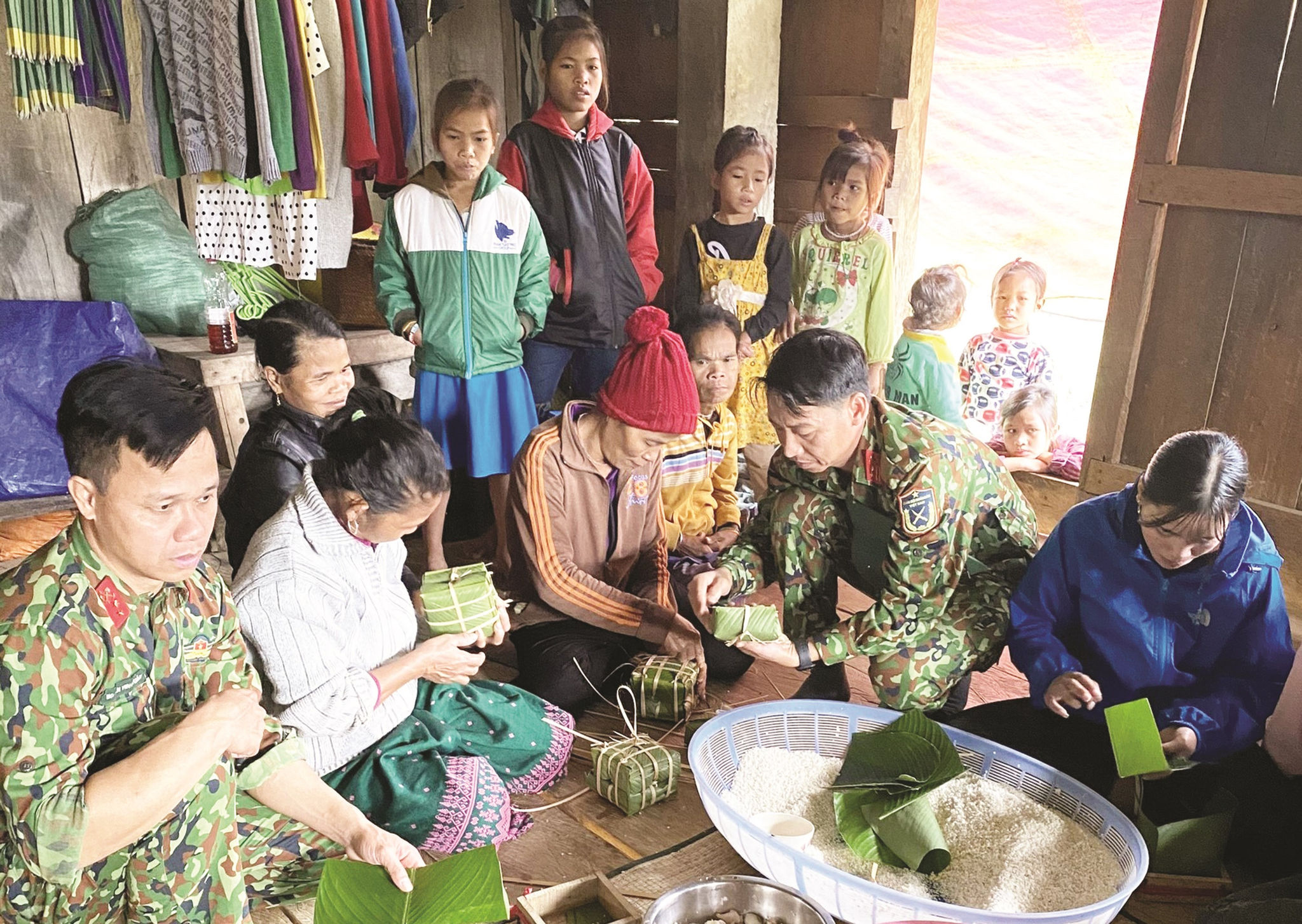 Cán bộ, chiến sĩ Lữ đoàn 414  hướng dẫn bà con bản Dộ-Tà Vờng gói bánh chưng.