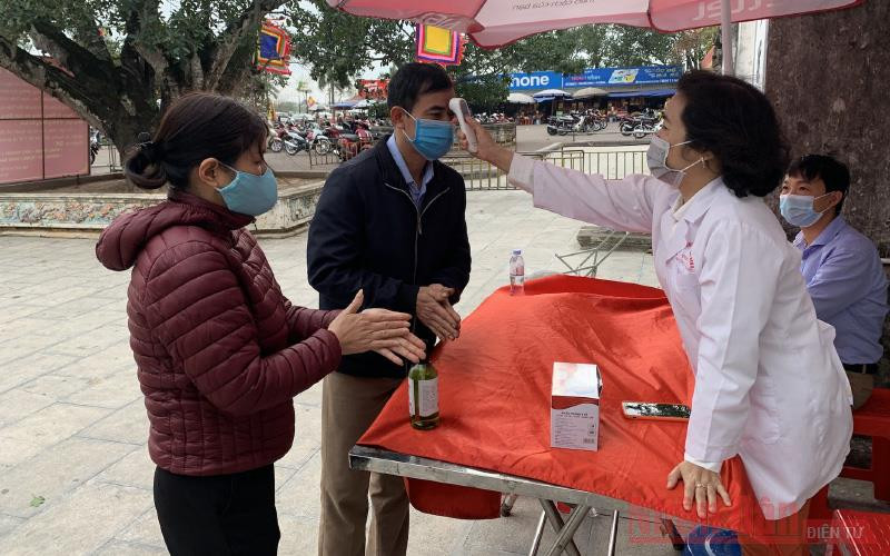 Người dân vào Đền Trần được đo thân nhiệt và rửa tay sát khuẩn phòng dịch. 
