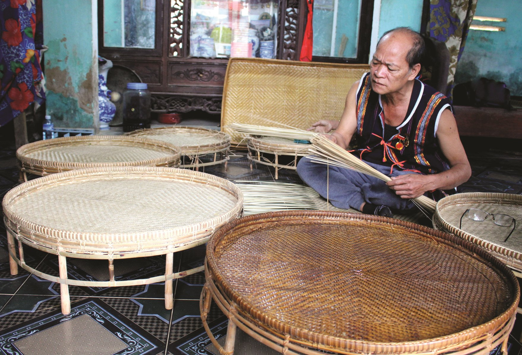 Già làng uy tín Alăng Phương đang đan mâm mây giữ nghề đan đát truyền thống của người Cơ Tu.