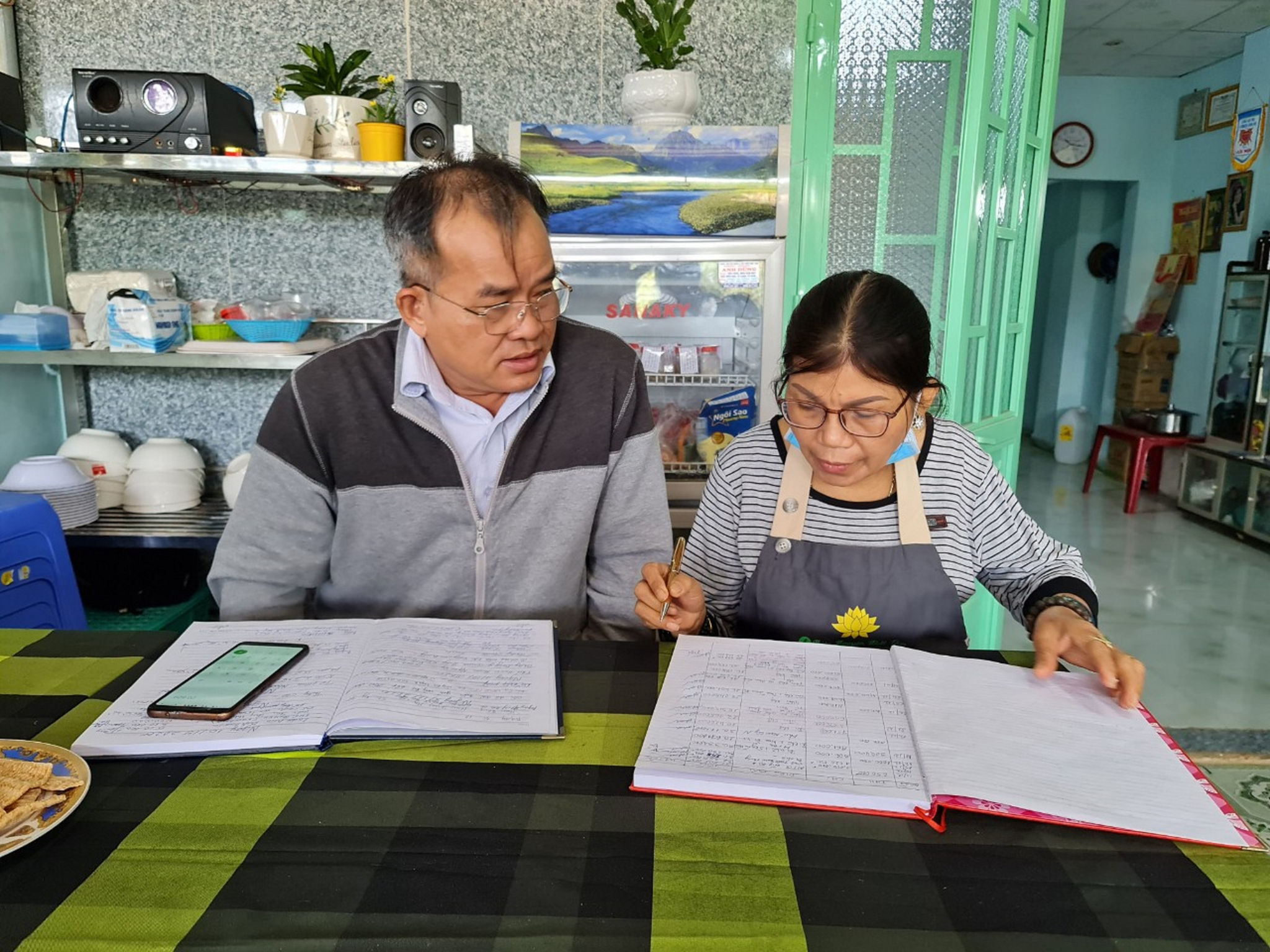 Bà Nguyễn Thị Kim Tuyết cùng cộng sự ghi chép sổ sách của nhà ăn 0 đồng Nhất Tâm