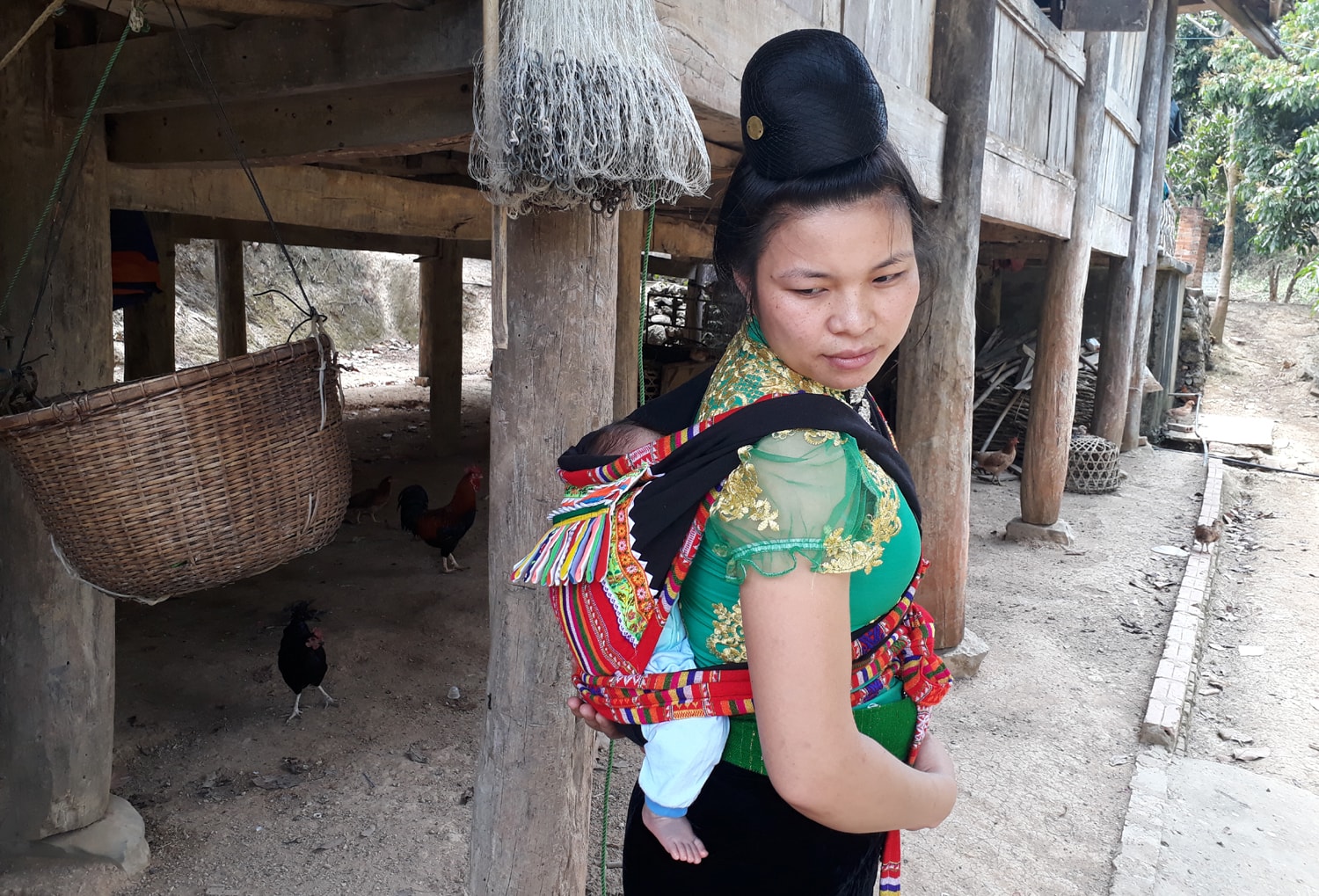 Những người mẹ dân tộc Thái thường địu con địu con trên lưng để tiện làm việc nhà