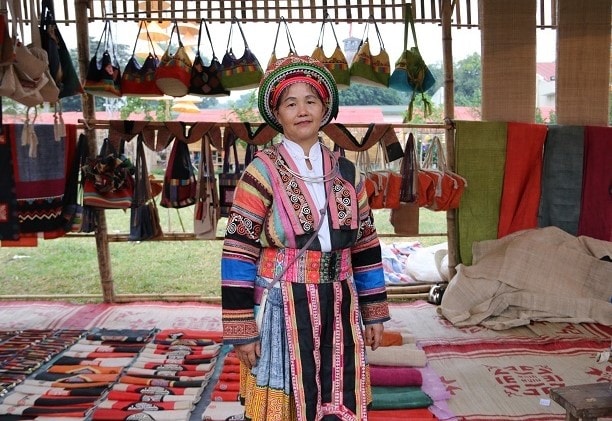 Nghệ nhân Vàng Thị Mai và gian hàng trưng bày các sản phẩm thổ cẩm của HTX dệt thổ cẩm Lùng Tám