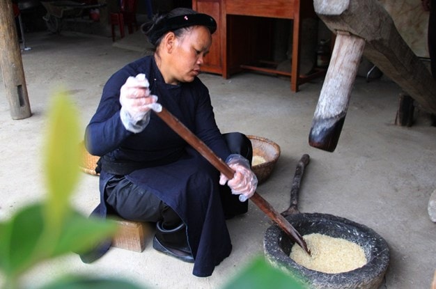 Lấy xôi đã phơi vào cối đá giã cho hạt xôi dẹt mỏng. Lấy xôi đã phơi vào cối đá giã cho hạt xôi dẹt mỏng.