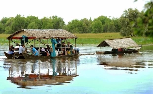 Du khách tham quan Vườn quốc gia Tràm Chim bằng nhà nổi trên sông. Ảnh: An Hiếu/TTXVN