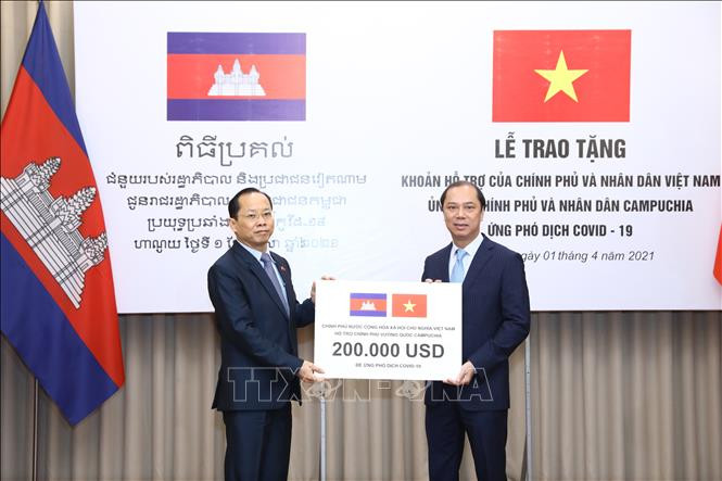 Thứ trưởng Bộ Ngoại giao Nguyễn Quốc Dũng trao tặng khoản hỗ trợ của Chính phủ và nhân dân Việt Nam ủng hộ Chính phủ và nhân dân Campuchia ứng phó dịch COVID-19. Ảnh: Văn Điệp/TTXVN