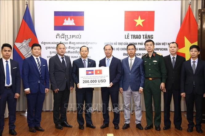 Thứ trưởng Bộ Ngoại giao Nguyễn Quốc Dũng trao tặng khoản hỗ trợ của Chính phủ và Nhân dân Việt Nam ủng hộ Chính phủ và Nhân dân Campuchia ứng phó dịch COVID-19. Ảnh: Văn Điệp/TTXVN