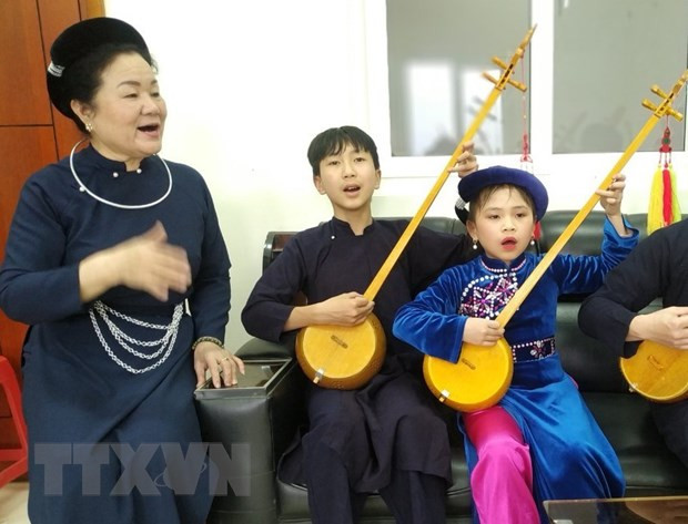 Nghệ sỹ ưu tú Hoàng Kim Tuế (trái) truyền dạy nghệ thuật hát then đàn tính cho thế hệ trẻ tỉnh Cao Bằng. (Ảnh: TTXVN phát)