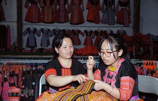 Chị Tráng Thị Dua (bên trái) truyền dạy nghề thêu, may truyền thống của đồng bào dân tộc Mông cho con gái. (Ảnh: Quang Quyết/TTXVN) Chị Tráng Thị Dua (bên trái) truyền dạy nghề thêu, may truyền thống của đồng bào dân tộc Mông cho con gái. (Ảnh: Quang Quyết/TTXVN)