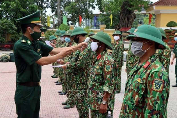 Kiểm tra thân nhiệt cán bộ, chiến sĩ trước khi lên đường làm nhiệm vụ. Ảnh: Đỗ Trưởng - TTXVN