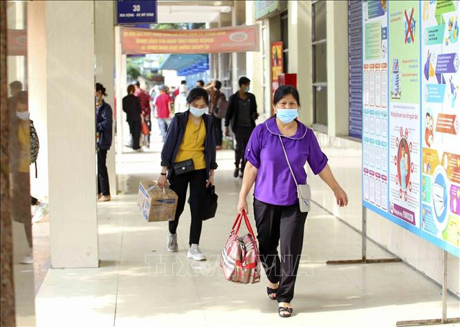 Người dân thực hiện đeo khẩu trang nơi công cộng. Ảnh: TTXVN