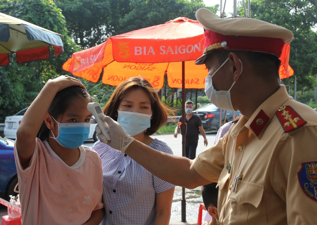 Lực lượng chức năng tiến hành đo thân nhiệt và khai báo y tế cho hành khách qua các chốt kiểm dịch