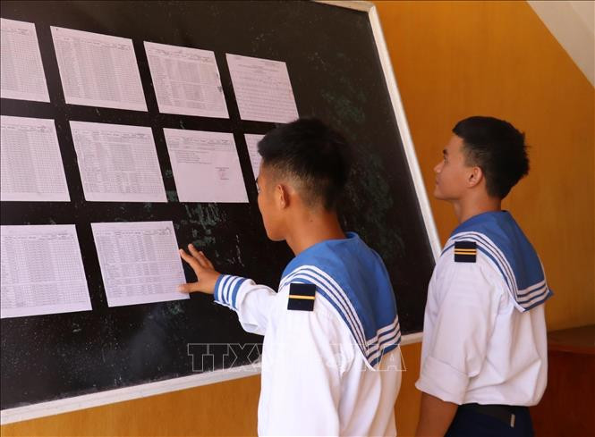 Hai chiến sỹ trẻ lần đầu tiên được đi bầu, theo dõi danh sách cử tri được niêm yết tại UBND xã Song Tử Tây (huyện Trường Sa, tỉnh Khánh Hoà).