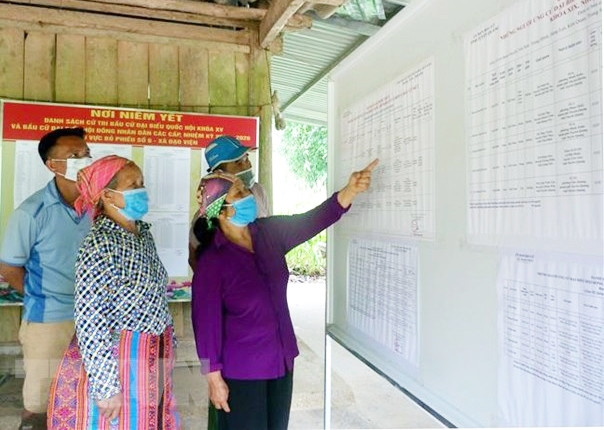 Cử tri thôn Ngòi Rịa, xã Đạo Viện, huyện Yên Sơn (Tuyên Quang) tìm hiểu thông tin về các ứng cử viên tại điểm niêm yết thông tin của thôn. (Ảnh: Vũ Quang Đán/TTXVN) 