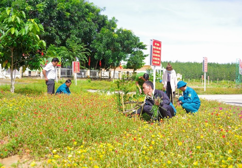 Trưởng thôn A Mão (áo đen) cùng…. đang chăm sóc vườn hoa tại…. Ngoài làm kinh tế giỏi anh A Mão còn rất tích cực tham gia công tác xây dựng NTM tại địa phương