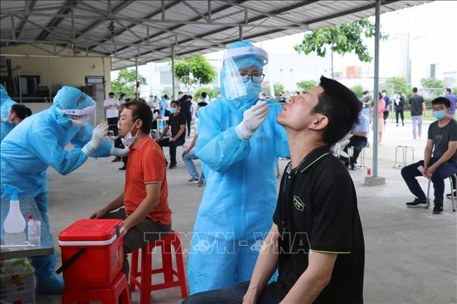 Lấy mẫu xét nghiệm cho người dân ở các khu vực nguy cơ. Ảnh: TTXVN