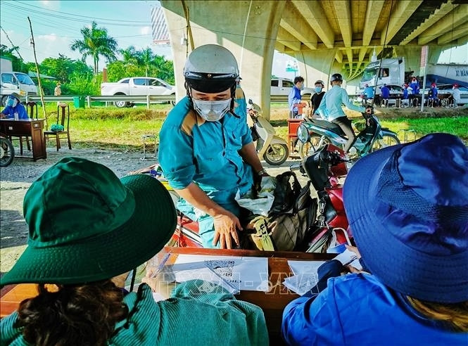 Người dân khai báo thông tin y tế tại các chốt kiểm soát. Ảnh: TTXVN