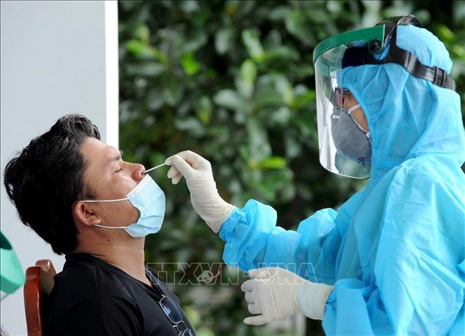 Lấy mẫu xét nghiệm sàng lọc ca bệnh COVID-19 trong cộng đồng. Ảnh: TTXVN