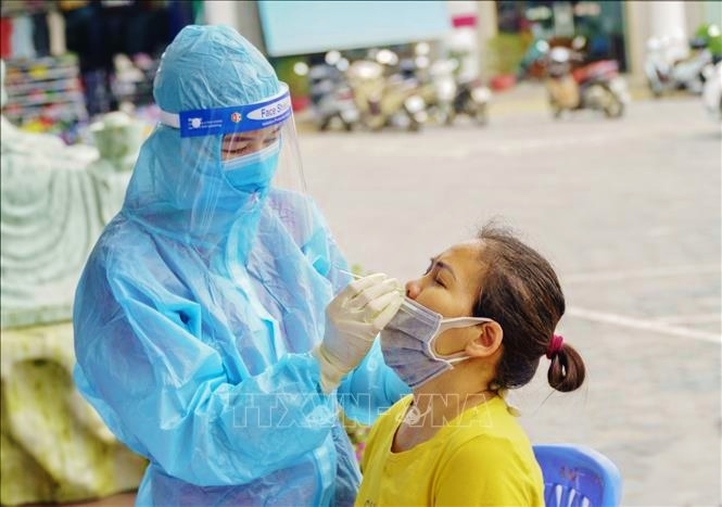 Lấy mẫu xét nghiệm COVID-19 cho người dân ở khu vực có nguy cơ cao. Ảnh: TTXVN