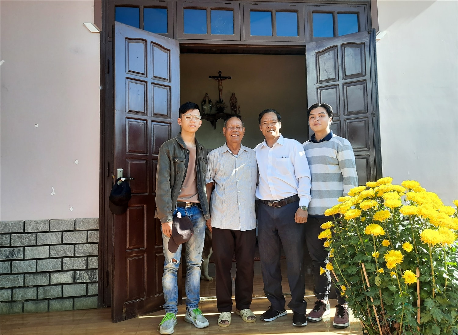 Ông Naria Ya Duck (thứ hai từ trái qua) trước ngôi nhà của mình 