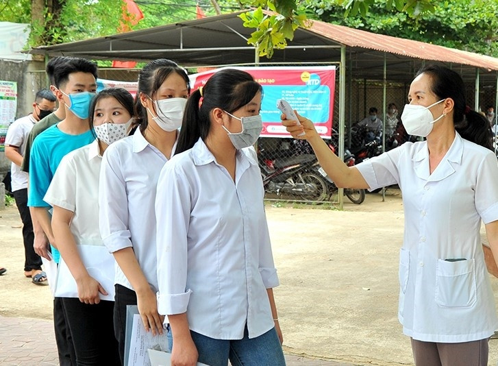 Các thí sinh được kiểm tra thân nhiệt trước khi vào thi Các thí sinh được kiểm tra thân nhiệt trước khi vào thi