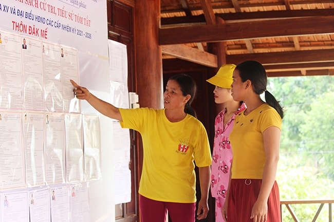 Chị Khiêm (bên trái) hướng dẫn người dân tìm hiểu về công tác bầu cử tại nhà Rông thôn Đắk Mế