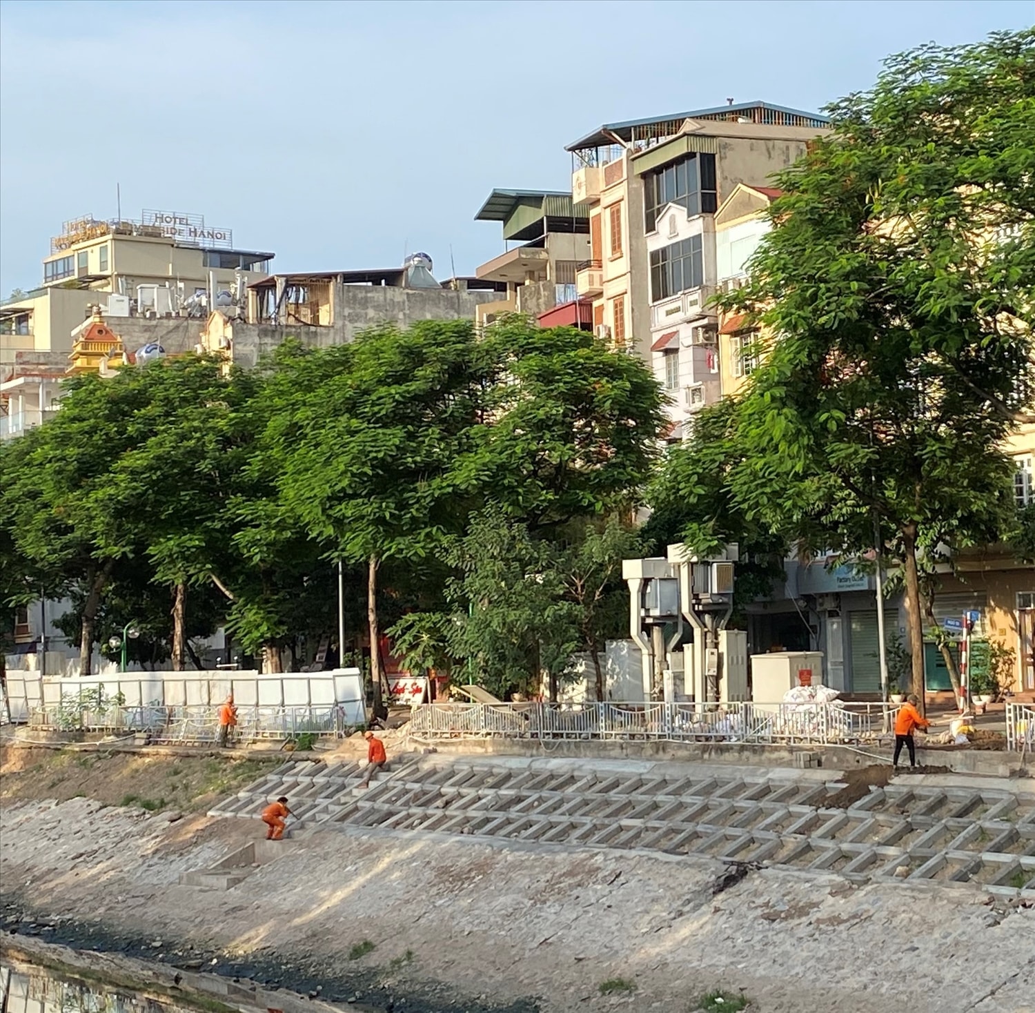 Công nhân Công ty Môi trường đô thị giữ khoảng cách khi  làm việc tại khu vực sông Tô Lịch thuộc địa bàn quận Cầu Giấy