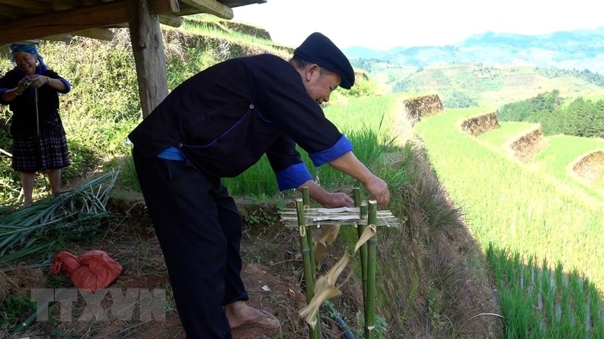 Trước khi vào lễ, chủ nhà phải cắm 4 cây tre và đan các thanh tre được bổ ra thành tấm phẳng dài, rộng chừng 20-30cm. (Ảnh: Tuấn Anh/TTXVN)
