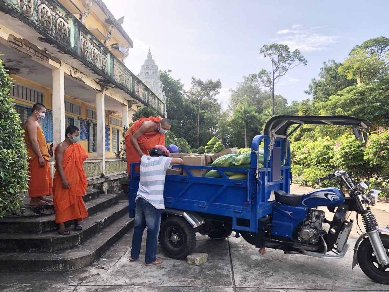 Các sư sãi cùng người dân vận chuyển hàng hóa nhu yếu phẩm đến điểm phân phát cho bà con