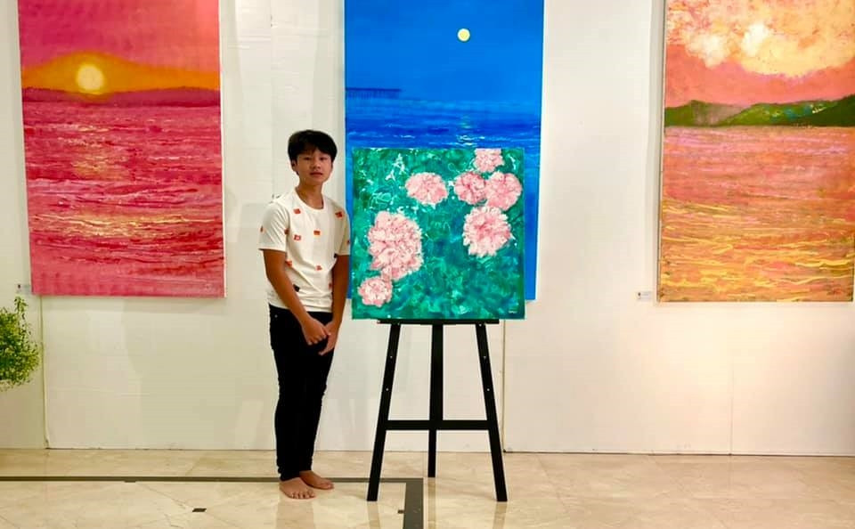 Xèo Chu bên bộ sưu tập tranh Biển và Hoa . Ảnh: nhân vật cung cấp